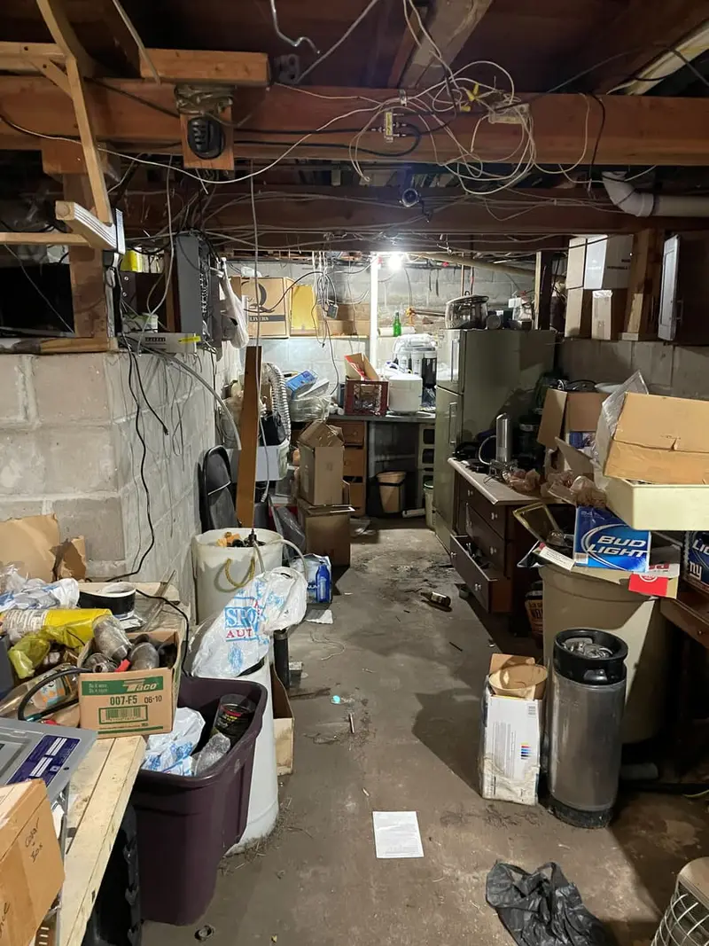 Unfinished basement crowded with boxes under exposed joists, Ronkonkoma, NY